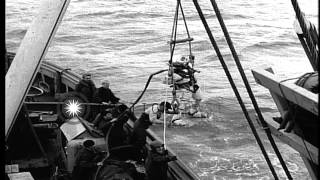 Allied diver in a hoist being lowered into the Atlantic Ocean during World War II...HD Stock Footage