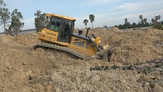 Dump trucks unloading dirt and bulldozer pushing dirt