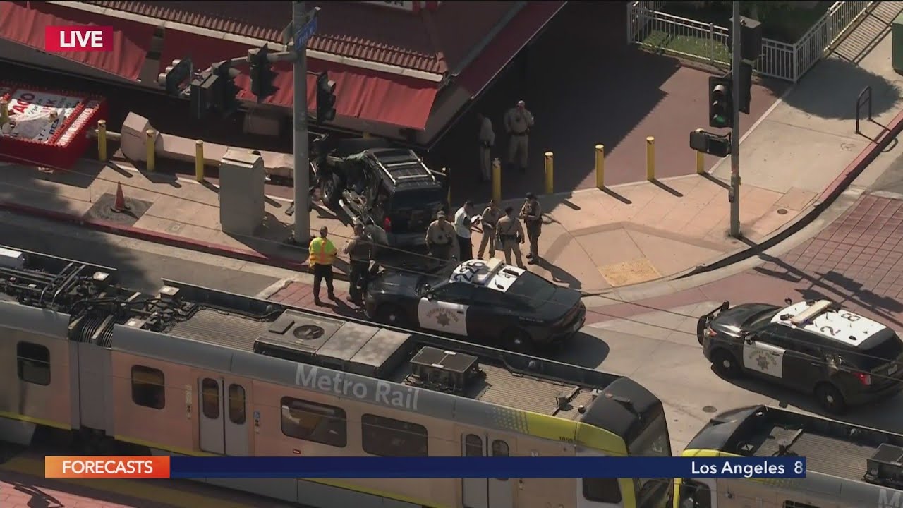 Car collides with train, crashes into King Taco sign