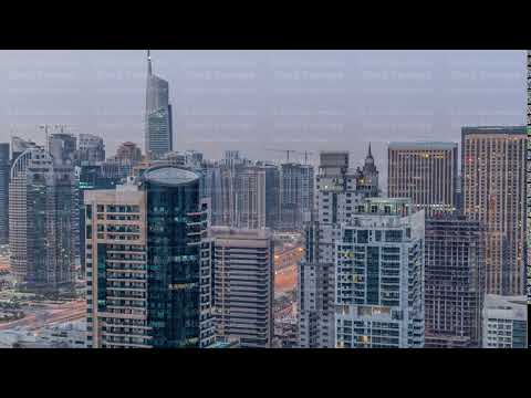 Aerial top view of Dubai Marina night to day timelapse. Modern towers and traffic on the road