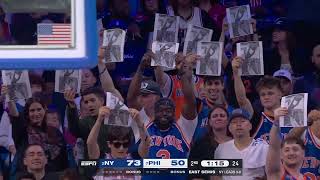 Knicks fans wave photos of Mitchell Robinson's poster dunk on Embiid, during Embiid's free throws