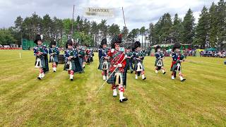 Drum Major leads Ballater Pipe Band around Games field in rain at 2025 Tomintoul Highland Games