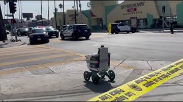 Delivery robot drives through crime scene