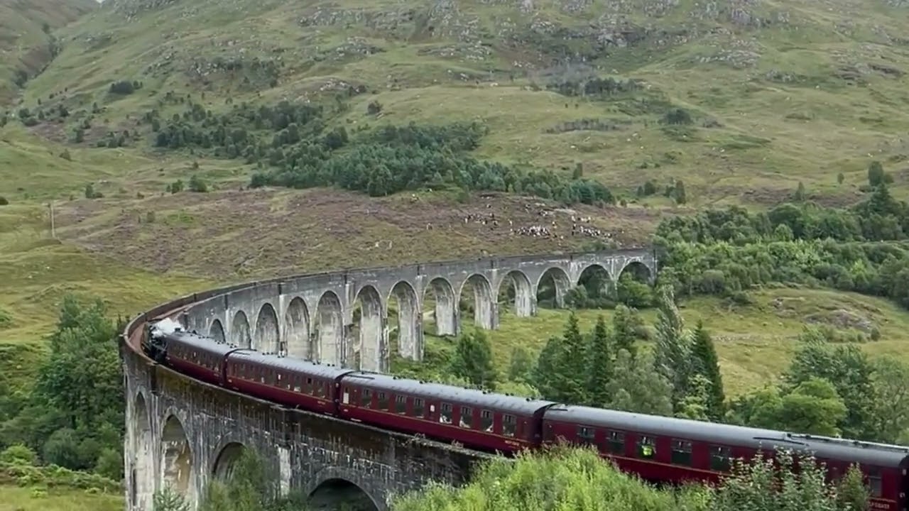 Jacobite steam train crossing Glenfinnan Viaduct Scotland UK