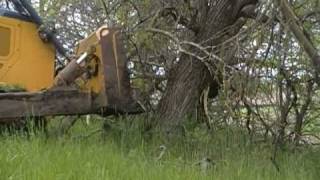 John Deere 850J pushing trees