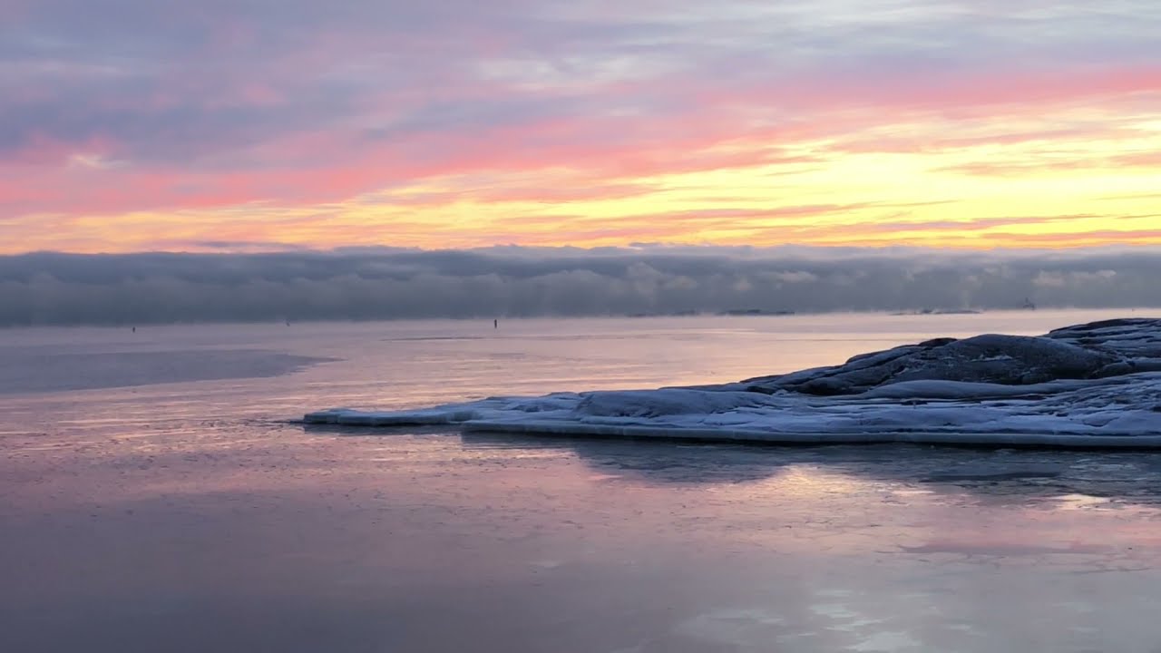 Winter sunset walk as a huge cloud wall spans the horizon by the seaside in Helsinki