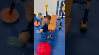 Boy lifts toy barbell then fall off bench