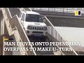 Man drives onto pedestrian overpass to make U-turn