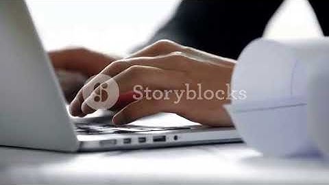 close up of young architect hands typing on laptop computer keyboard in white modern office in the s