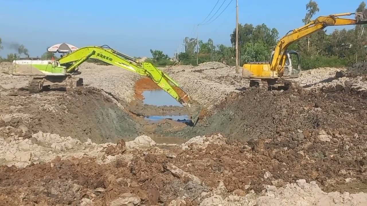 Hai xe cuốc phối hợp đào đắp bờ cho con đường mới