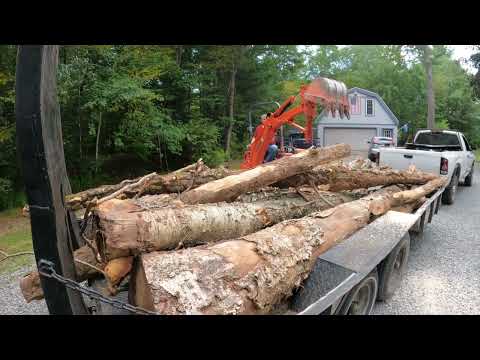 Unloading logs with a backhoe - Unloading logs with a backhoe