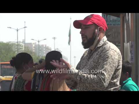 Man communicates in sign language with another man at Safdarjung bus stop