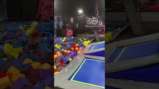 Boy jumps from platform onto trampoline then into foam pit and little brother does a belly flop
