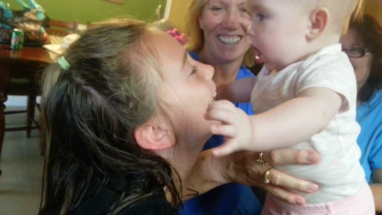 Baby eating her sisters face!