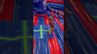 Boy gets hit by blue swinging arm ride in bounce house