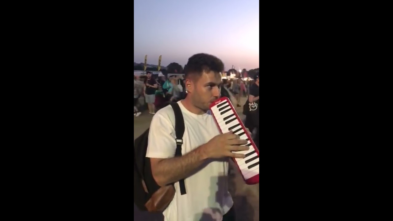 Guy plays better off alone on melodica at festival ORIGINAL