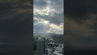 Bright sun shining above the city through clouds