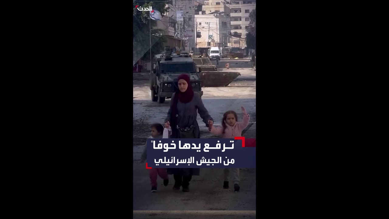 طفلة ترفع يدها خوفاً من آليات الجيش الإسرائيلي خلفها كي يصلن بأمان إلى والدها