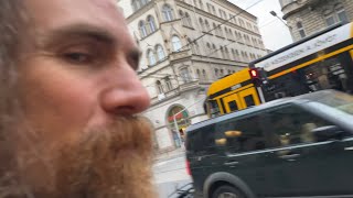 Walking Man Tries To Get His Hat Fixed In Budapest