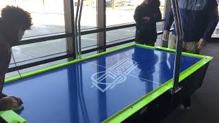 Two Guys Play Air Hockey in a Movie Theatre