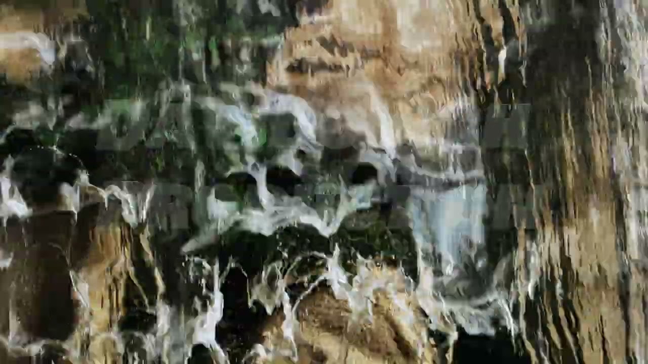 Water flowing on mossy rocks creating a beautiful waterfall in Vietnam