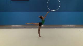 Rotate a hoop, throw and catch with an arabesque