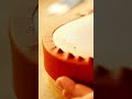 Drummaker secures hide to clay drum with rhythmic hammering