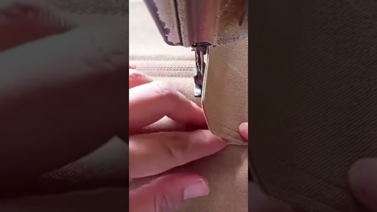 sewing a brown fabric using a professional industrial machine to create a strong and neat garment