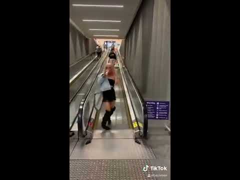 Girl Falls While Walking Off Airport Escalator 1113512