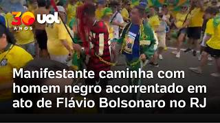 Bolsonaro supporter walks with chained Black man dressed as a PT supporter at Flávio rally
