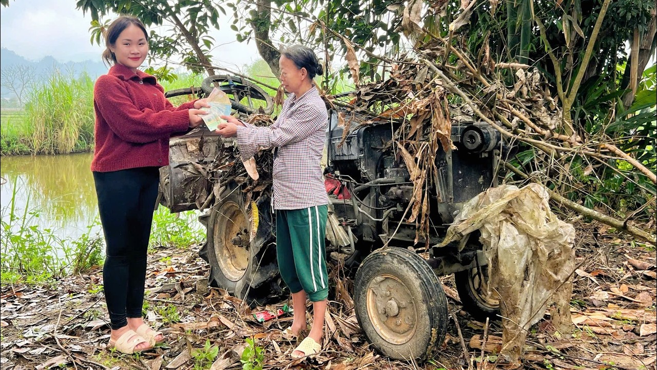 Girl repairs and restores the engine of a broken agricultural tractor.