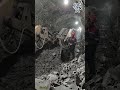 Workers operate excavators to dig tunnels