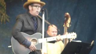 ELVIS COSTELLO and THE SUGARCANES at JAZZ FEST 2010. 2010-04-29 JIMMIE  STANDING IN THE RAIN