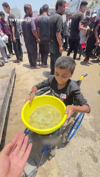 Disabled Palestinian child struggles through crowd for a meal
