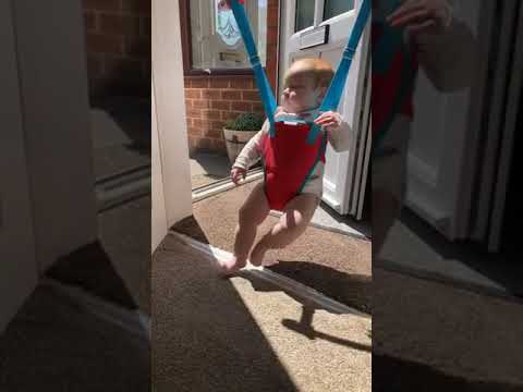 Little Girl Bounces to Music Sitting in Baby Jumper - 1130812
