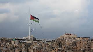 Jordanian flag in Amman-flying birds سرب من الطيور يجري إستعراض أثناء رفع سارية العلم الأردني