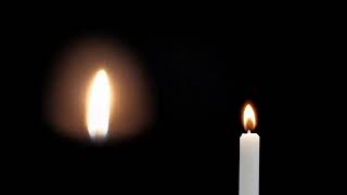 Пламя свечи и свеча горящая на черном фоне