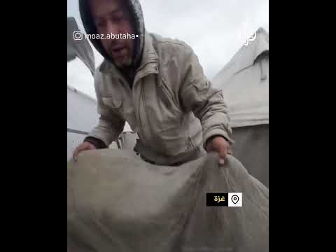 نازح يلملم ما تبقى من خيمته بعد جرف البحر لها في قطاع غزة