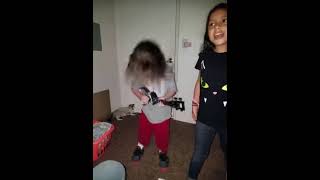 Girl head bangs while playing ukulele and bumps back of head on door