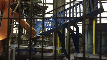 Automatisierte Beladung einer Durchlauf-Sandstahlanlage für schwere Bleche mit einem KUKA-Roboter
