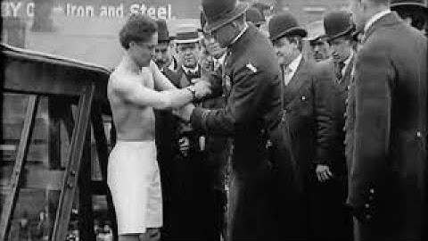Harry Houdini jumps off a bridge handcuffed--and escapes
