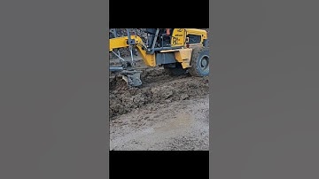 The haul road gets wet due to rain, causing the grader