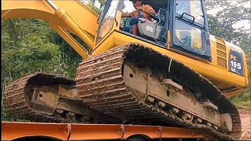 Here is the process of loading and unloading an excavator onto a self-loader truck .