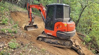 Hillside tank pad and water trench under culvert with the Kubota KX-040