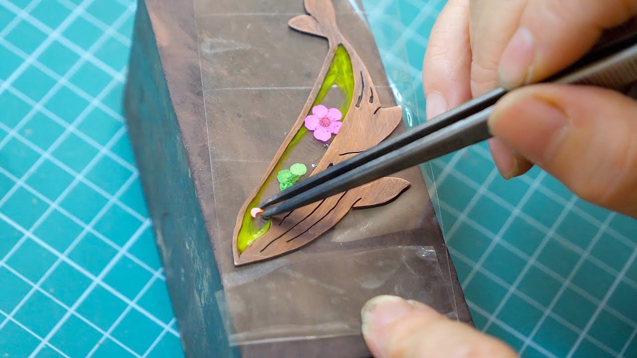 The process of making dolphin-shaped ornaments. Korean cloisonne craftsman.