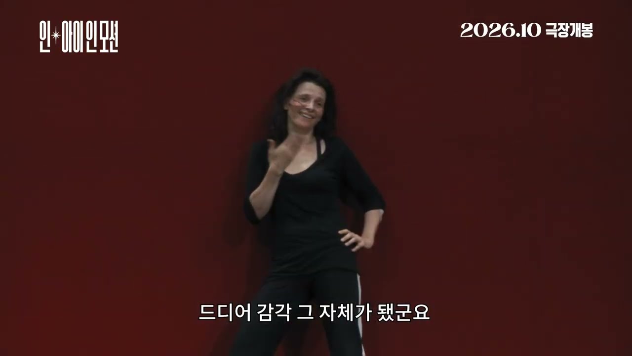 붉은 벽 앞에서 손을 들어 보이는 검은 옷 여성과 '드디어 감각 그 자체가 됐군요' 자막
