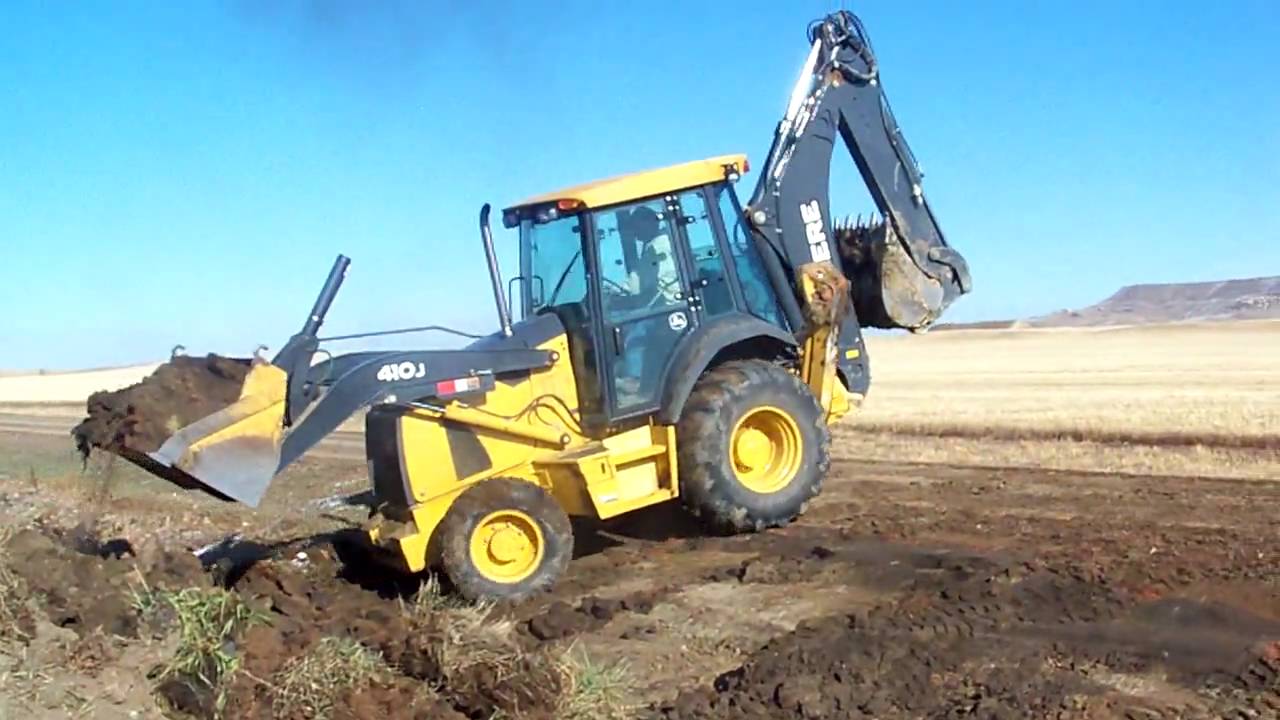 John Deere 410J back hoe filling in a culvert at the farm...