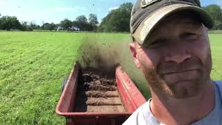 Spreading manure on hay field.