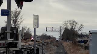 Northbound Frontrunner train passes by a nearby park in cloudy weather