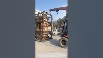 The process of two forklifts working together to move a gatehouse.